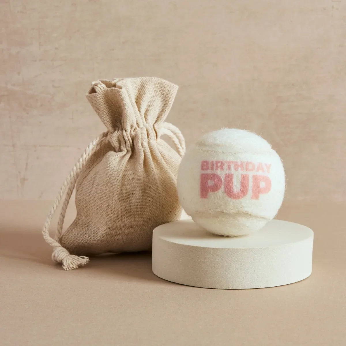 Cream tennis ball printed with 'Birthday Pup' text in pink and linen bag, Pet Hamper