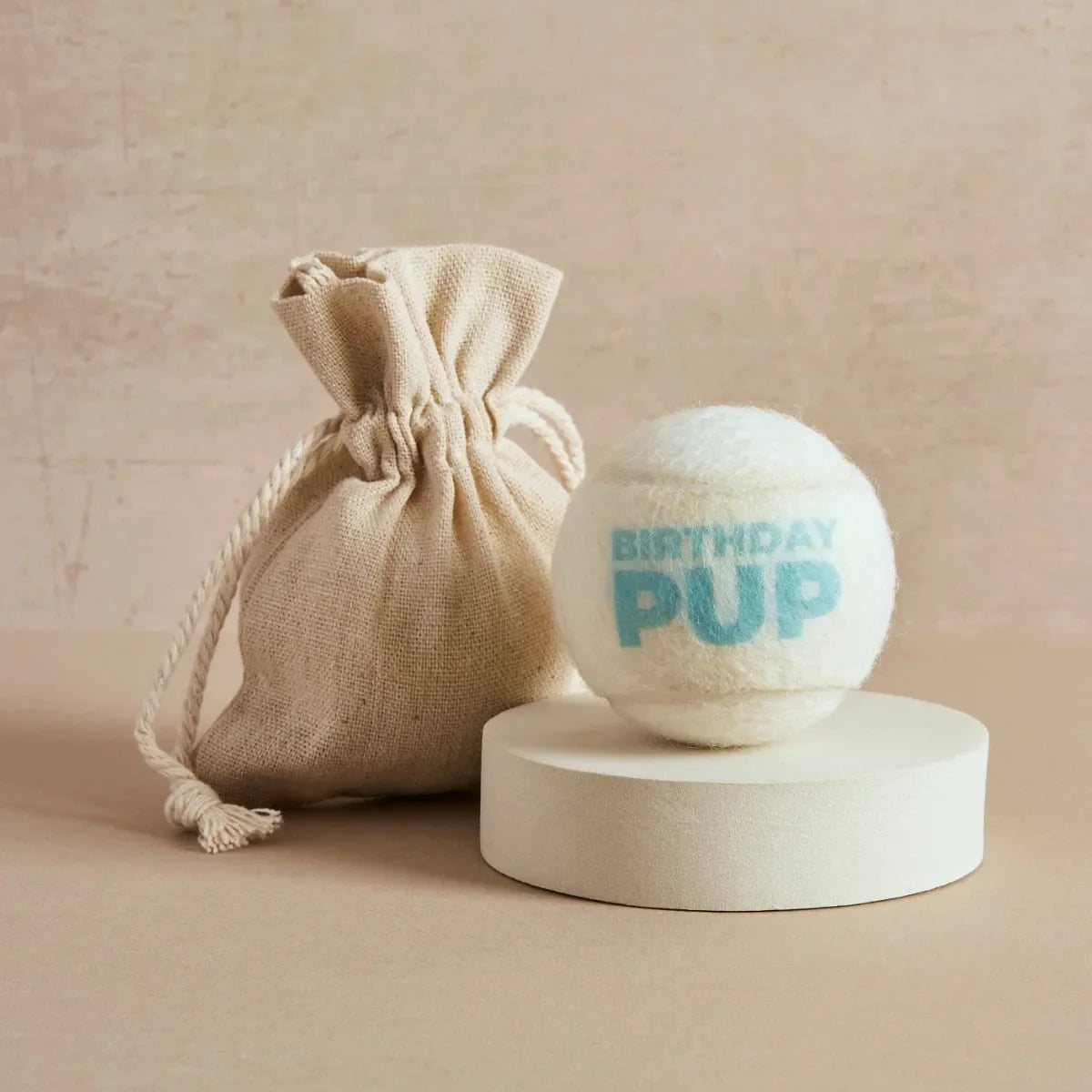 Cream tennis ball printed with 'Birthday Pup' text in blue and linen bag, Pet Hamper