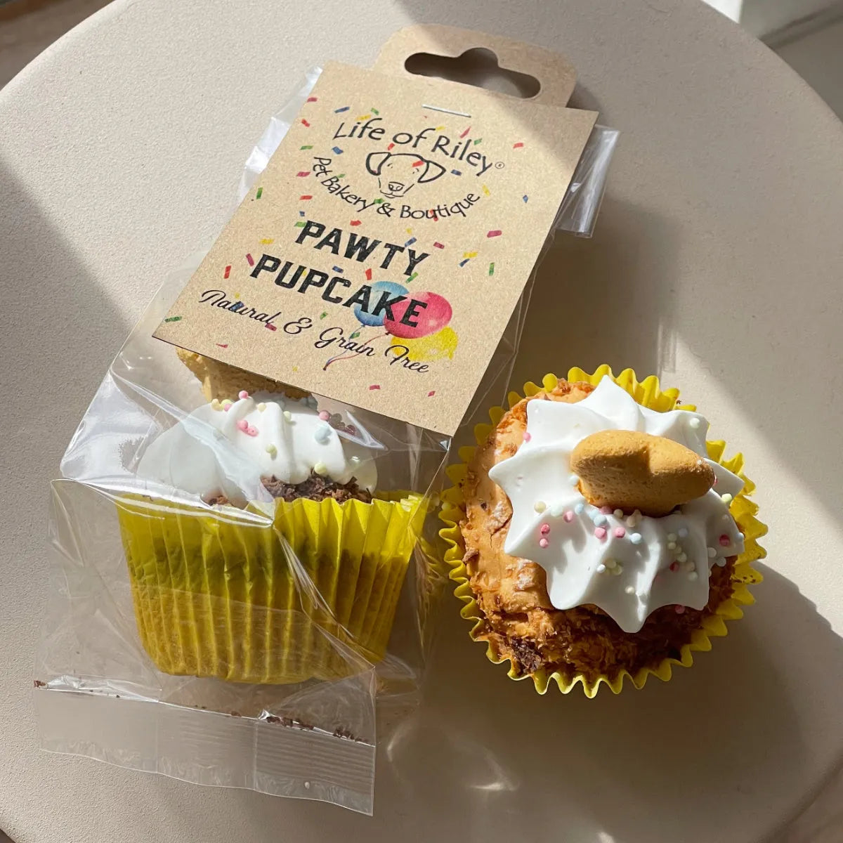 Grain-free dog cupcake treat with white icing and bone topper, Life Of Riley Pawty Pupcake