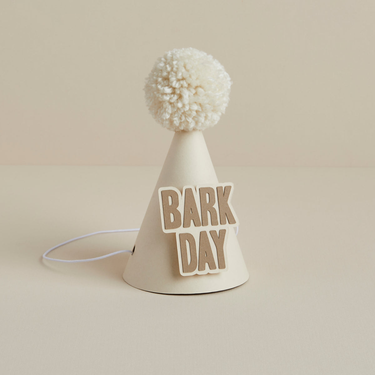 Cream dog party hat with wool pom-pom and 'Bark Day' decoration